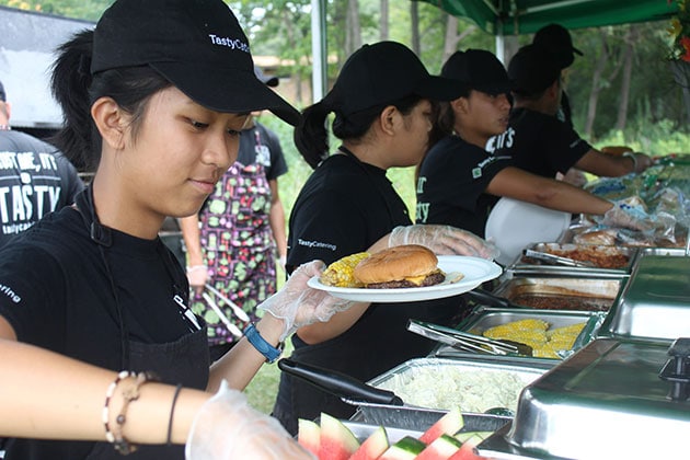 Staff Place Food on Plates for Guests