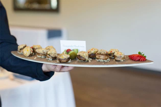 Mushroom appetizer being passed on a tray by a server