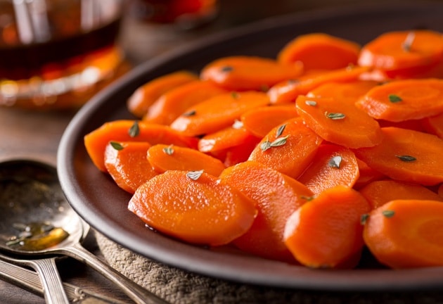 Roasted orange carrot slices on a dark plate