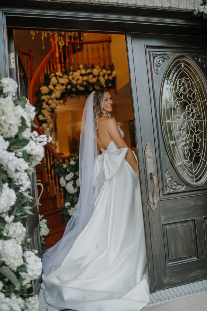 Bride in doorway showing off dress.