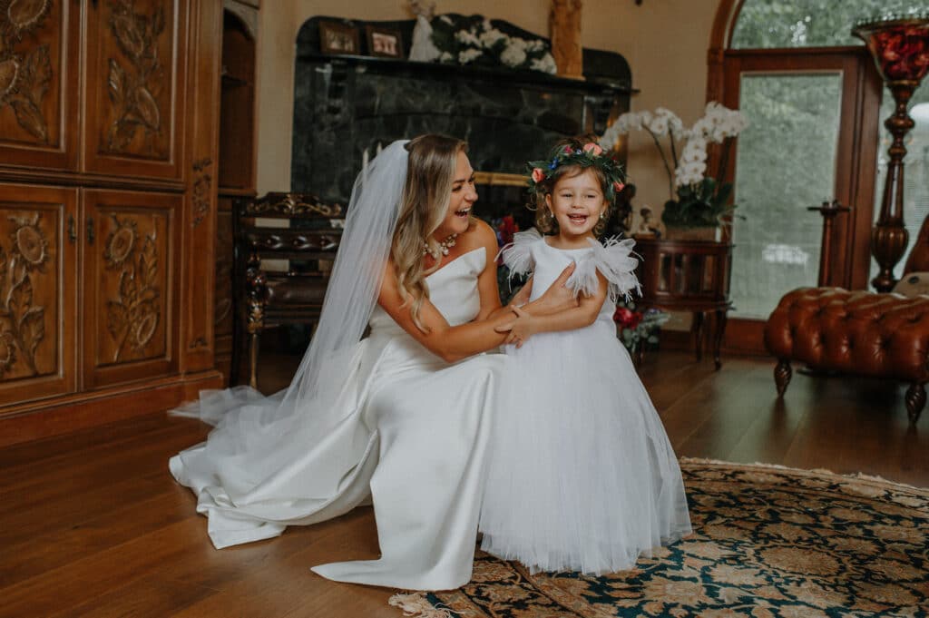 Bride laughing with flowergirl.