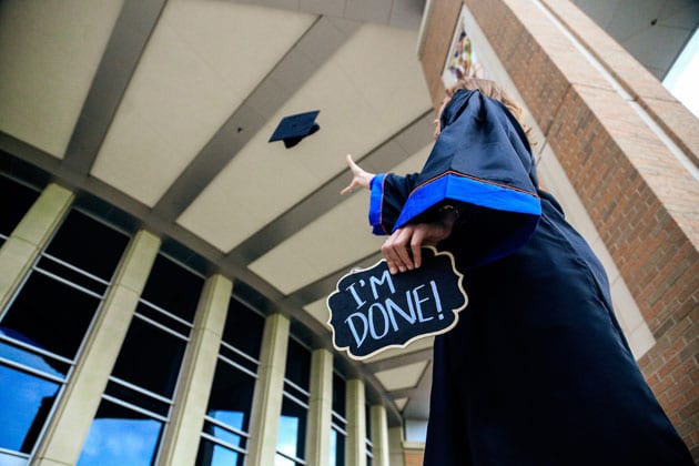 graduate throwing hat with sign saying 'I'm Done'