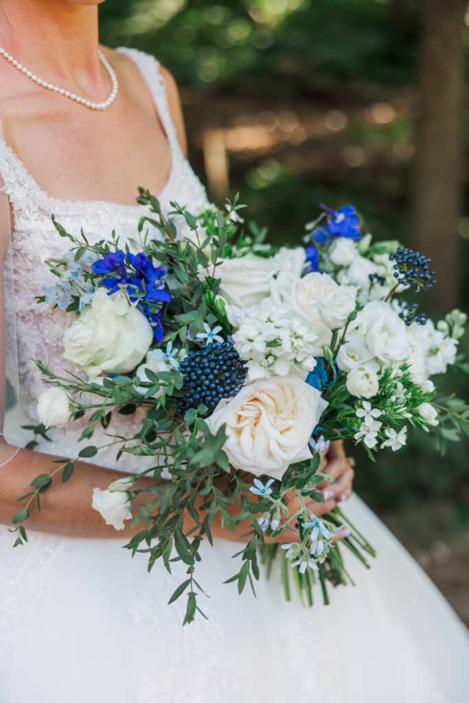 bride holding blue and white flowers
